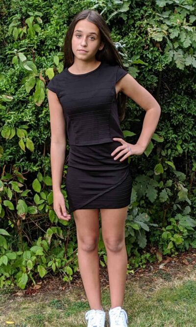 Teenage girl wearing a Sally Miller Morgan Two Piece in Black. Fabulous bandage look two piece set with a cap sleeve and asymmetric bodycon skirt from Silhouette London, Girls party dress specialists in London