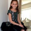 Dolls and Divas Chloe Dress 3 Young Girl sitting wearing Dolls and Divas Chloe Dress in Aztec Design sequins and black tulle Skirt from Girls Party Fashion Boutique Silhouette London