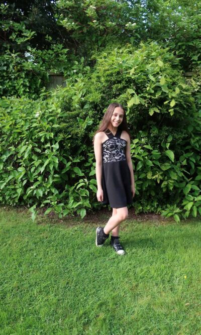Young Girl wearing Lace and Jersey V Strap Skater dress in Black/Nude from Silhouette London, Girls Prom and Party Dress Boutique in London