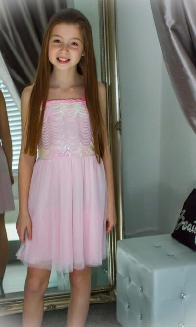 Model wearing a Elisa B Dress Style 6692E in Pink from Silhouette London, Girls party dress specialists in London.