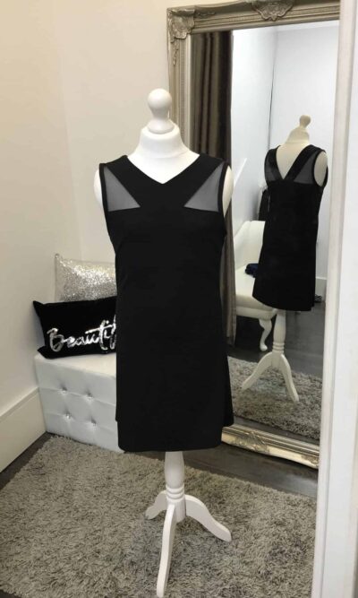 Mannequin wearing aSally Miller Shannon Dress in Black with Mesh shoulder detail a slight A line shape from Silhouette London Teen Party Fashion Specialists in Greater London