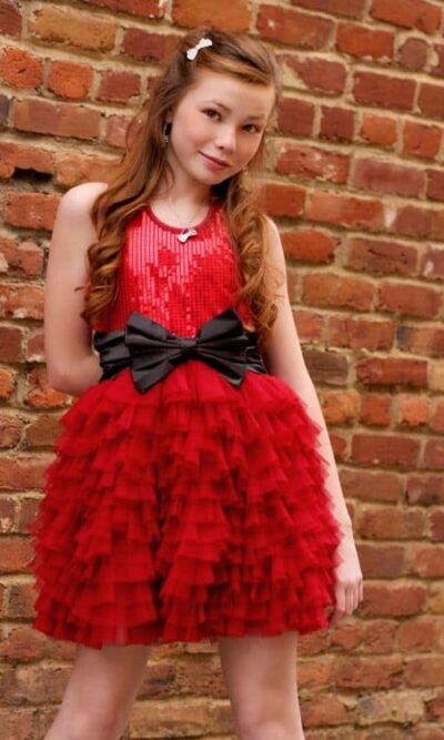 Young Girl wearing anOoh la la Couture Wow Dream Dress in Red with Black Bow from Silhouette London a Girls Party Dress Specialist Boutique in Greater London