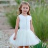 Dolls and Divas Sheri Dress 3 Young girl wearing Dolls and Divas Couture Sheri Tutu Dress in Ivory, Scuba top with diamante detail and full tulle skirt, from Silhouette London, a girls party fashion boutique in Harrow, Greater London