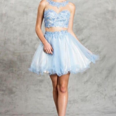 Blonde teenager wearing a Aspeed Design Dress Style S1482 in Periwinkle Blue. lace and tulle two piece with full tulle skirt with scalloped edge and fabulous lace and tulle illusion neckline on the top from Silhouette London, Girls party dress specialists in London.